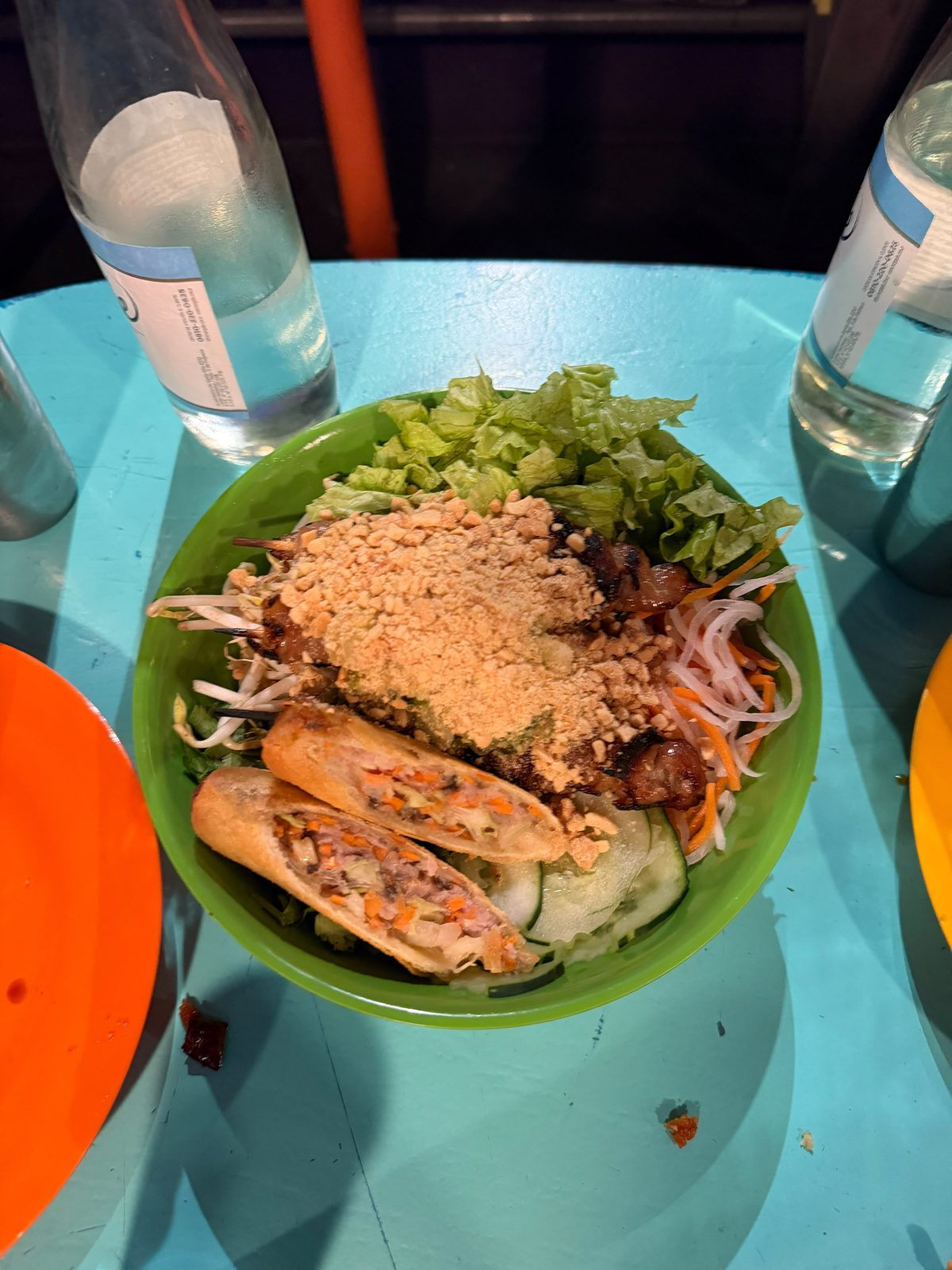Bun Thit Nuong de Cang Tin en un bol verde: cerdo con maní, fideos de arroz, nems fritos, lechuga y brotes de soja
