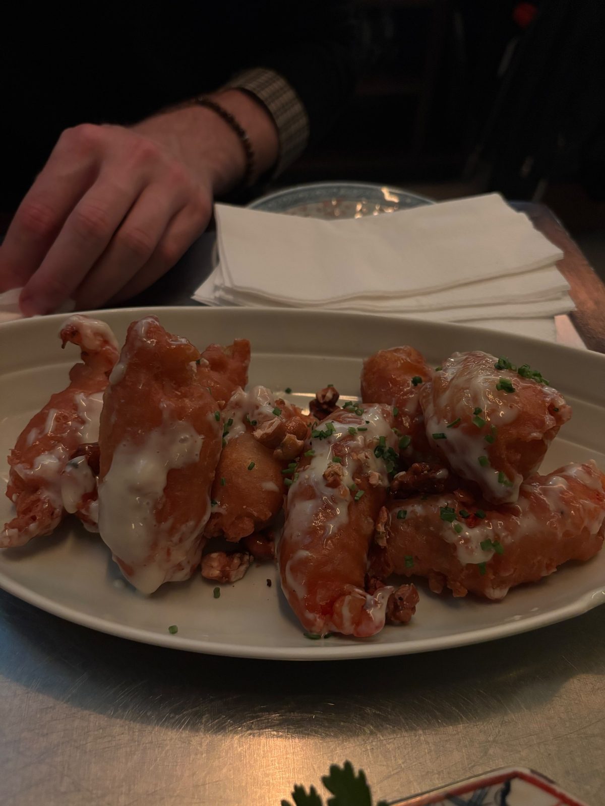Honey Caju Shrimp de Tony Wu: langostinos rebozados con salsa blanca, castañas de cajú y ciboulette en una fuente ovalada